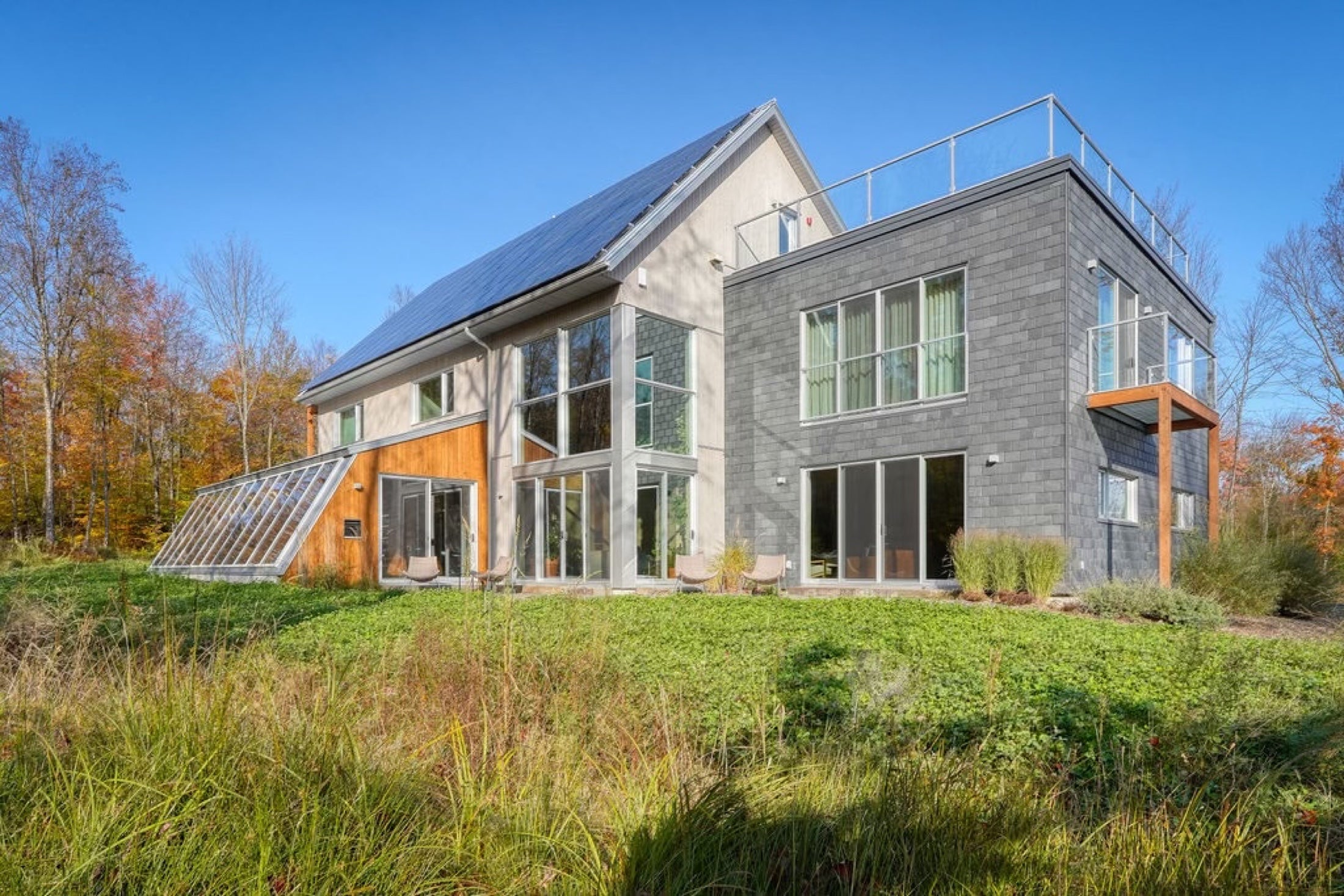 Vue extérieure du Pavillon Oasis entouré par la forêt d'automne