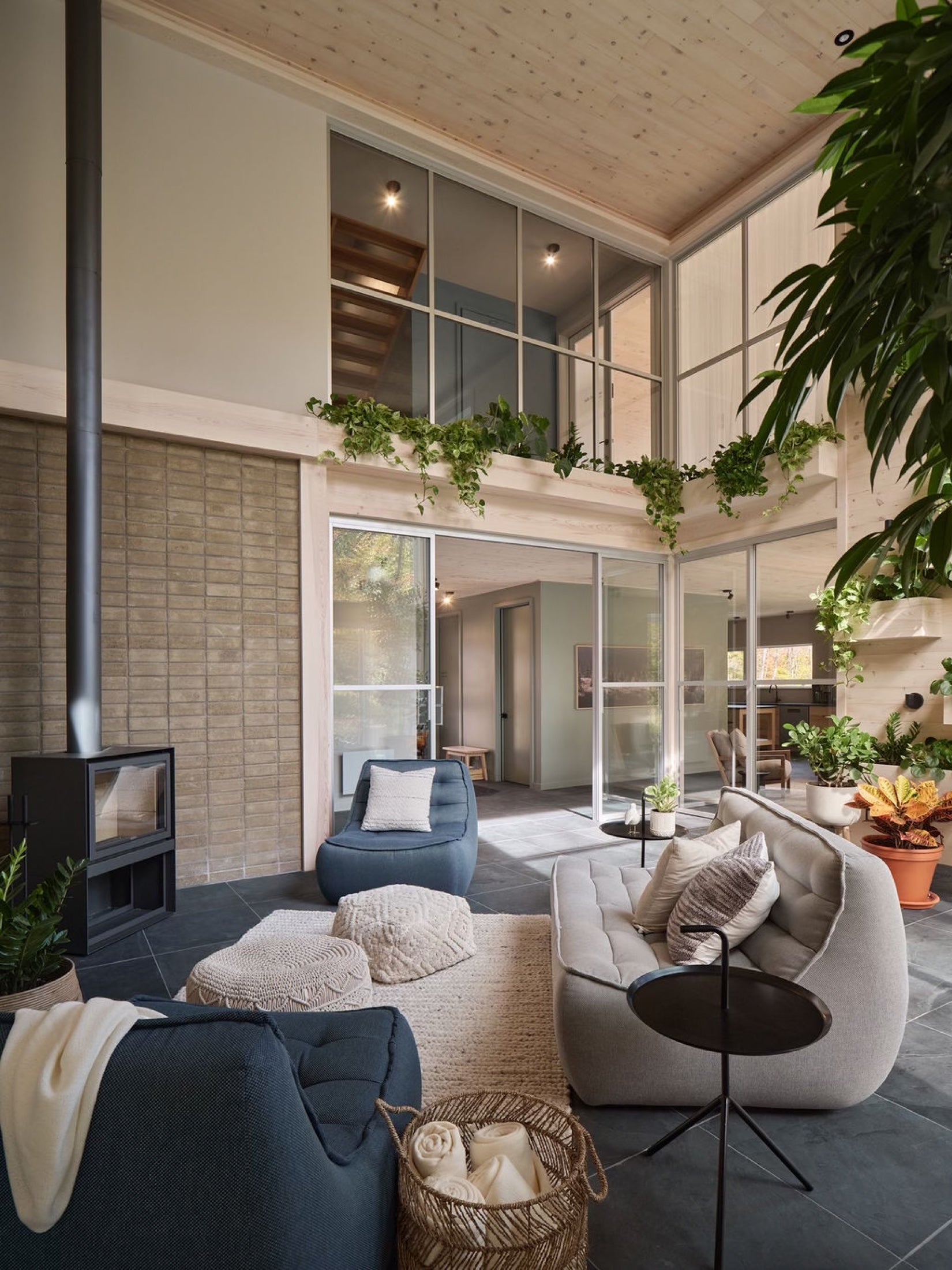 Solarium lumineux du Pavillon Oasis avec foyer, plantes et fauteuils